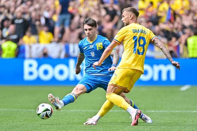 Bild zeigt: Tsygankov (15, Ukraine), Dragus (19, Rumänien), 17.06.2024, München, Fussball, Europameisterschaft, Rumänien - Ukraine, EVENT REGULATIONS PROHIBIT ANY USE OF PHOTOGRAPHS AS IMAGE SEQUENCES AND OR QUASI-VIDEO.