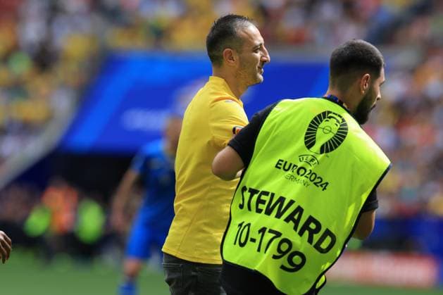 17th June 2024; Munich Football Arena, Munich, Germany; Euro 2024 Group E Football, Romania versus Ukraine; a Romaniam fan enters the field of play and is escorted off by security steward  ActionPlus12655820 PierrexTeyssot