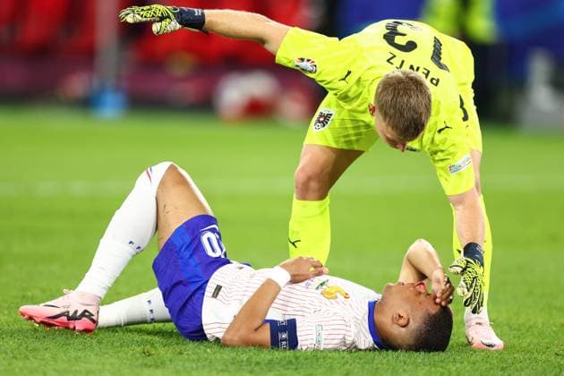 Austria v France 17 June 2024, Dusseldorf - UEFA EUROs - Group D - Austria v France - Austria goalkeeper Patrick Pentz checks on Kylian Mbappe of France as his nose starts bleeding - Photo: Charlotte Wilson Offside. Dusseldorf Germany Copyright: xCharlottexWilsonx xOffsidexOffside
