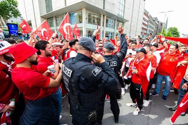 18.06.2024 - Fußball, Europameisterschaft 2024 in Deutschland, Fans in Dortmund Türkei - Georgien: Türkische Fans mit Polizisten mittags vor dem Spiel in der Innenstadt. Ein Polizist feiert kurz mit.