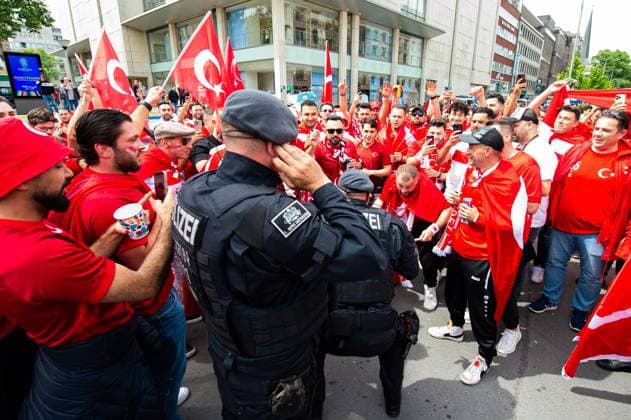 18.06.2024 - Fußball, Europameisterschaft 2024 in Deutschland, Fans in Dortmund Türkei - Georgien: Türkische Fans mit Polizisten mittags vor dem Spiel in der Innenstadt. Ein Polizist feiert kurz mit.