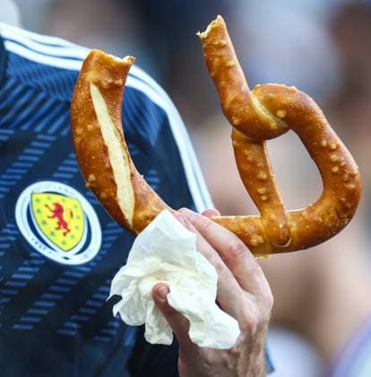 Switzerland v Scotland 19 June 2024, Cologne - UEFA EUROs - Group A - Switzerland v Scotland - A Scotland fan with a large pretzel - Photo: Charlotte Wilson Offside. Cologne Germany Copyright: xCharlottexWilsonx xOffsidexOffside