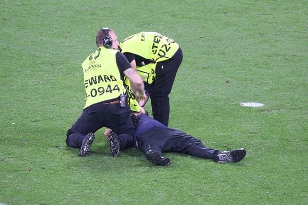 Leipzig, Sachsen-Anhalt, Deutschland, 18.06.2024: Red-Bull-Arena: Fußball-EM 2024, Gruppe F, Portugal - Tschechien: Stewards (Ordner) fixieren einen Zuschauer, der zuvor auf das Spielfeld gestürmt ist (sogenannter Flitzer), um Selfies mit den Spielern Portugals zu machen. Copyright: xdtsxNachrichtenagenturx dts_40853