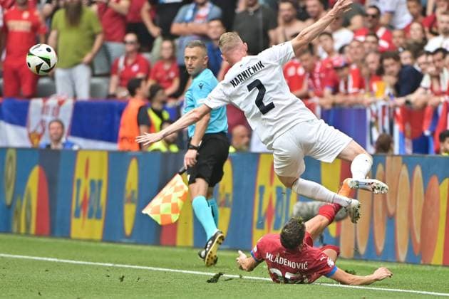 Bild zeigt: v.l.n.r. Filip Mladenovic (25, Serbien) mit Grätsche gegen Zan Karnicnik (2, Slowenien), 20.06.2024, München, Fussball, Europameisterschaft, Slowenien - Serbien, EVENT REGULATIONS PROHIBIT ANY USE OF PHOTOGRAPHS AS IMAGE SEQUENCES AND OR QUASI-VIDEO.