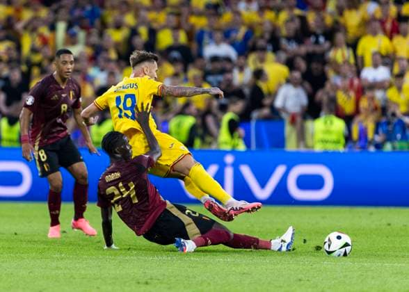 Koeln, RheinEnergieStadion, 22.06.2024: Amadou Onana of belgium challenges Denis Dragus of romania during the match UEFA European Championship, EM, Europameisterschaft 2024 Belgium v. Romania.