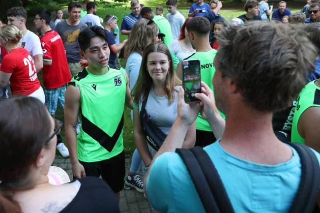 23.06.2024, xtgx, Fussball 2. Bundesliga, Hannover 96 Auftakttraining emspor, v.l. Hyunju Lee (Hannover) macht Fotos mit Fans (DFL DFB REGULATIONS PROHIBIT ANY USE OF PHOTOGRAPHS as IMAGE SEQUENCES and or QUASI-VIDEO) Hannover