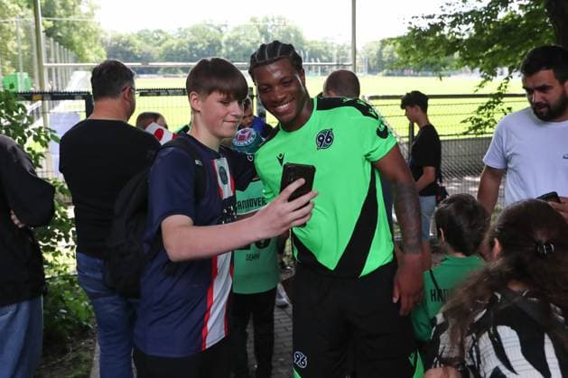 23.06.2024, xtgx, Fussball 2. Bundesliga, Hannover 96 Auftakttraining emspor, v.l. Jessic Ngankam (Hannover) macht Fotos mit Fans (DFL DFB REGULATIONS PROHIBIT ANY USE OF PHOTOGRAPHS as IMAGE SEQUENCES and or QUASI-VIDEO) Hannover