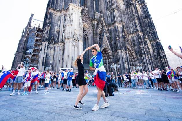 25.06.2024 - Fußball, Europameisterschaft 2024 in Deutschland, Fans in Köln England - Slowenien: Ein slowenischer Fan tanzt vor dem Spiel am Kölner Dom mit einer Fernsehmoderatorin, wahrscheinlich aus Slowenien. Köln Nordrhein-Westfalen Deutschland