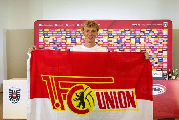 Fussball, Herren, Saison 2023 2024, EM 2024 in Deutschland, Pressekonferenz der Nationalelf von Österreich im ÖFB Media Center Berlin (Marshall-Haus Messe Berlin), Leopold Querfeld (Österreich) mit Fahne seines zukünftigen Vereins 1. FC Union Berlin, 26.06. 2024, Copyright: xMatthiasxKochx