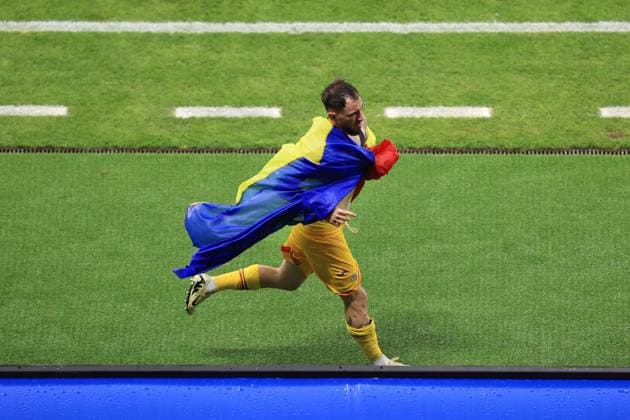 Football - UEFA EURO, EM, Europameisterschaft,Fussball 2024 - Group E - Slovakia v Romania 26th June 2024 - UEFA EURO 2024 - Group E - Slovakia v Romania - Andrei Ratiu of Romania sprints down the touchline wearing his country s flag after the match - Photo: Simon Stacpoole Offside. Frankfurt Germany Copyright: xSimonxStacpoolexOffside
