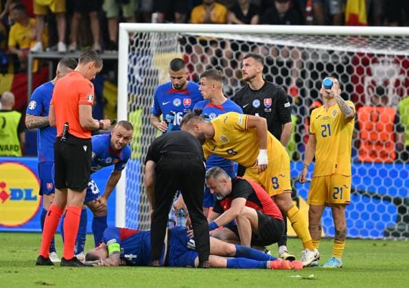26.06.2024, xsltx, Fussball EM 2024, Slowakei - Rumänien emspor, v.l. Schiedsrichter Daniel Siebert, Milan Skriniar (Slowakei) Behandlung, George Alexandru Puscas (Rumänien Rumaenien) (DFL DFB REGULATIONS PROHIBIT ANY USE OF PHOTOGRAPHS as IMAGE SEQUENCES and or QUASI-VIDEO) Frankfurt