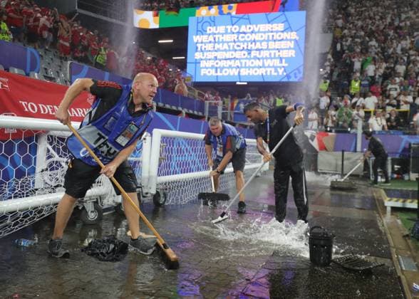 Dortmund, Germany, 29th June 2024. Ground staff clear the area around the pitch following a thunderstorm which caused the suspension of play during the UEFA European Championships Group 16 match at the BVB Stadion, Dortmund. Picture credit should read: Paul Terry Sportimage EDITORIAL USE ONLY. No use with unauthorised audio, video, data, fixture lists, club league logos or live services. Online in-match use limited to 120 images, no video emulation. No use in betting, games or single club league player publications. SPI-3213-0043