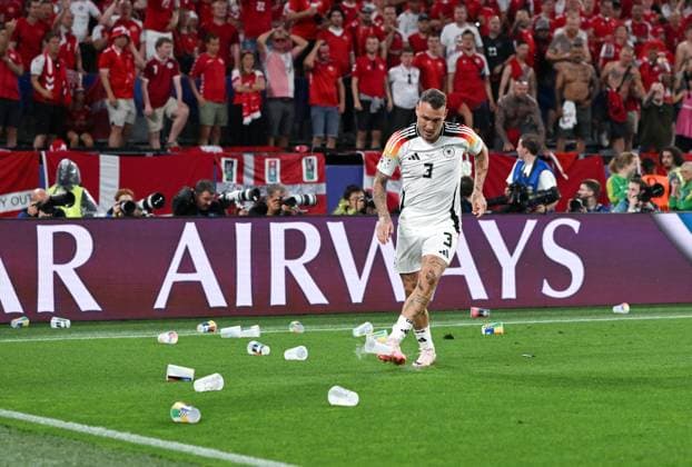 David Raum (Deutschland) beseitigt nach dem 1:0 geworfene Bierbecher vom Spielfeld 29.06.2024, Fussball Europameisterschaft 2024, Achtelfinale Deutschland - Dänemark 2:0 Dortmund Nordrhein Westfalen Deutschland