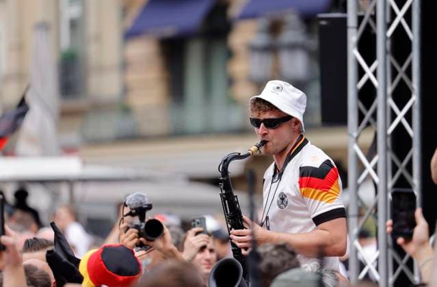 Deutschland - Hessen - Frankfurt am Main - 23.06.2024 Fußball Europameisterschaft 2024 EM-Typ mit dem Saxophon, Saxofonist im Völler-Trikot, Andre Schnura mit dem schwarzen Saxophon Public-Viewing in Frankfurt