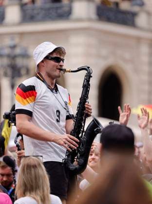 Deutschland - Hessen - Frankfurt am Main - 23.06.2024 Fußball Europameisterschaft 2024 EM-Typ mit dem Saxophon, Saxofonist im Völler-Trikot, Andre Schnura mit dem schwarzen Saxophon Public-Viewing in Frankfurt