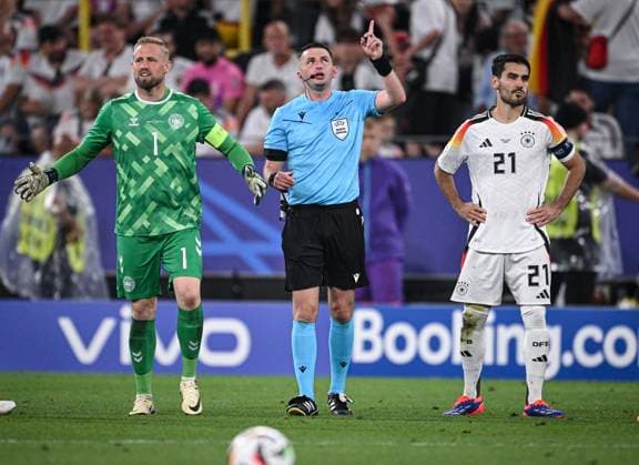 Fussball Euro 2024 Achtelfinale 29.06.2024 Deutschland - Daenemark Schiedsrichter Michael Oliver (Enland) holte die beiden Kapitaene Ilkay Guendogan (re, Deutschland) und Torwart Kasper Schmeichel (li, Daenemark) zu sich, um offenbar auf einen SEK Polizei Einsatz unter dem Dach des Stadion hinzuweisen.
