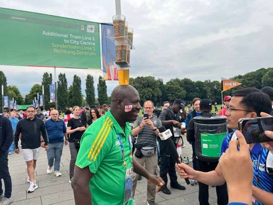 Volunteer begeistert ausländische Videoteams mit seiner Bierbecherjonglage auf dem Kopf - Köln 30.06.2024: Spanien vs. Georgien, EURO2024 M37, Achtelfinale, EM-Arena Köln
