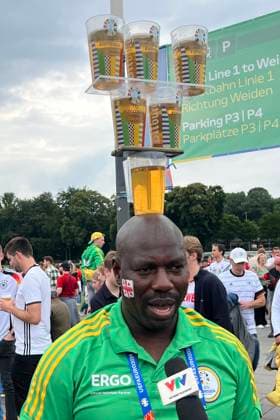 Volunteer begeistert ausländische Videoteams mit seiner Bierbecherjonglage auf dem Kopf - Köln 30.06.2024: Spanien vs. Georgien, EURO2024 M37, Achtelfinale, EM-Arena Köln