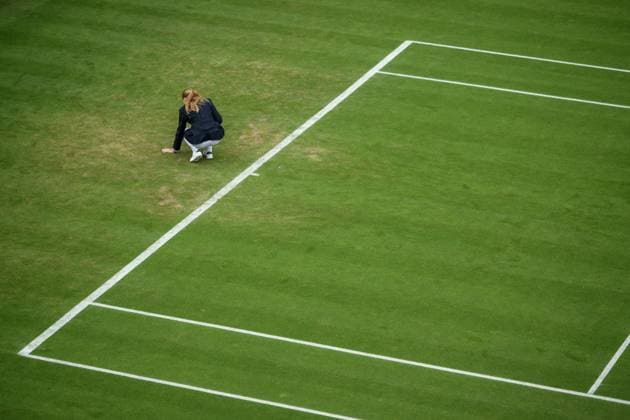 240702 An umpire checks the grass during day 2 of Wimbledon on July 2, 2024 in London. Photo: Jesper Zerman BILDBYRAN kod JZ JZ0548 tennis wimbledon AELTC day 2 bbeng Copyright: JESPERxZERMAN BB240702JZ008