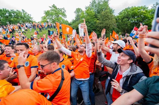 02.07.2024 - Fußball, Europameisterschaft 2024 in Deutschland, Fans in München Rumänien - Niederlande: Niederländische Fans vor dem Spiel beim Fanmarsch in der Nähe des Olympiaparks. Passanten schauen von einem Berg aus auf den Fanmarsch.