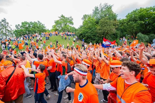 02.07.2024 - Fußball, Europameisterschaft 2024 in Deutschland, Fans in München Rumänien - Niederlande: Niederländische Fans vor dem Spiel beim Fanmarsch in der Nähe des Olympiaparks. Passanten schauen von einem Berg aus auf den Fanmarsch.