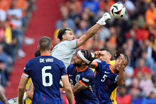 020724 KAI SCHWOERER Florin Nita of Romania makes a save against Memphis Depay of the Netherlands and Nathan Ake of the Netherlands (L-R) during the UEFA EURO, EM, Europameisterschaft,Fussball 2024 round of 16 match between Romania and the Netherlands at Munich Football Arena on July 2, 2024 in Munich, Germany. 020724-CPL-ROUvNED-011