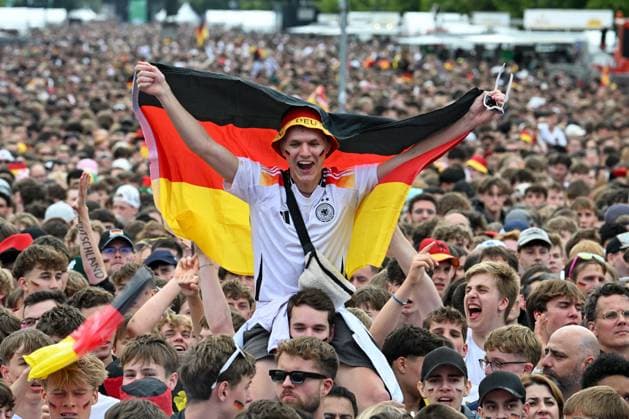 Berlin, Deutschland 5. Juli 2024: Fußball - Europameisterschaft 2024 Viertelfinale: Spanien gegen Deutschland Im Bild: Jubelnde Fans in der Fanzone Brandenburger Tor, ein männlicher Fan schwenkt lachend eine Deutschlandflagge Deutschlandfahne *** Berlin, Germany July 5, 2024 European Football Championship 2024 Quarterfinal Spain vs. Germany In the picture Cheering fans in the fan zone Brandenburger Tor, a male fan laughing and waving a German flag Germany flag Copyright: xFotostandx xReuhlx