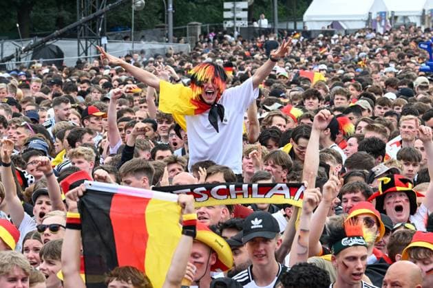 Berlin, Deutschland 5. Juli 2024: Fußball - Europameisterschaft 2024 Viertelfinale: Spanien gegen Deutschland Im Bild: Jubelnde Fans in der Fanzone Brandenburger Tor mit Deutschlandflaggen, ein männlicher Fan streckt die Arme nach oben Copyright: xFotostandx xReuhlx