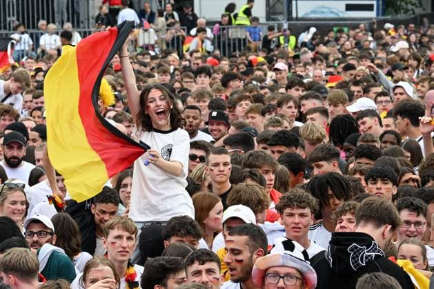 Berlin, Deutschland 5. Juli 2024: Fußball - Europameisterschaft 2024 Viertelfinale: Spanien gegen Deutschland Im Bild: Jubelnde Fans in der Fanzone Brandenburger Tor, ein weiblicher Fan schwenkt lachend eine Deutschlandflagge Deutschlandfahne Copyright: xFotostandx xReuhlx