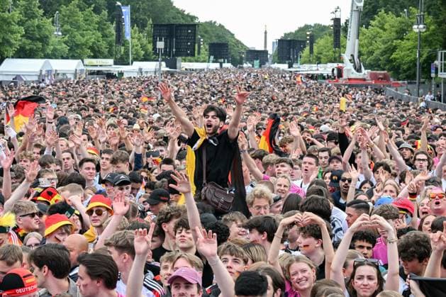 Berlin, Deutschland 5. Juli 2024: Fußball - Europameisterschaft 2024 Viertelfinale: Spanien gegen Deutschland Im Bild: Jubelnde Fans in der Fanzone Brandenburger Tor mit Deutschlandflaggen, ein männlicher Fan streckt die Arme nach oben Copyright: xFotostandx xReuhlx