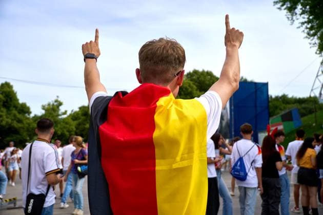 Munich, Bavaria, Germany - July 5, 2024: Public viewing in the fan zone in Munich s Olympiapark for the quarter-final of UEFA EURO, EM, Europameisterschaft,Fussball 2024 Germany vs. Spain. In the picture a Germany fan with flag cheering
