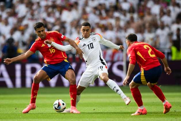 Sport Bilder des Tages Spain v Germany - UEFA EURO, EM, Europameisterschaft,Fussball 2024 Jamal Musiala of Germany competes for the ball with Rodri and Dani Carvajal of Spain during the UEFA EURO 2024 quarter-final football match between Spain and Germany. Stuttgart Germany Copyright: xNicolòxCampox