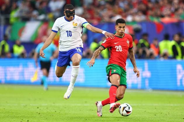 Portugal v France 5 July 2024, Hamburg - UEFA EUROs - Quarter-Final - Portugal v France - Kylian Mbappe of France with a protective face mask and Joao Cancelo of Portugal - Photo: Charlotte Wilson Offside. Hamburg Germany Copyright: xCharlottexWilsonx xOffsidexOffside