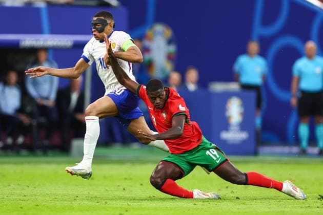 Portugal v France 5 July 2024, Hamburg - UEFA EUROs - Quarter-Final - Portugal v France - Kylian Mbappe of France with a protective face mask and Nuno Mendes of Portugal - Photo: Charlotte Wilson Offside. Hamburg Germany Copyright: xCharlottexWilsonx xOffsidexOffside