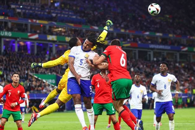 Portugal v France 5 July 2024, Hamburg - UEFA EUROs - Quarter-Final - Portugal v France - Jules Kounde of France and Joao Palhinha of Portugal jump for the ball as France goalkeeper Mike Maignan punches it away - Photo: Charlotte Wilson Offside. Hamburg Germany Copyright: xCharlottexWilsonx xOffsidexOffside