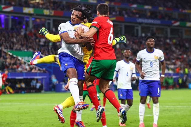 Portugal v France 5 July 2024, Hamburg - UEFA EUROs - Quarter-Final - Portugal v France - Jules Kounde of France and Joao Palhinha of Portugal jump for the ball as France goalkeeper Mike Maignan punches it away - Photo: Charlotte Wilson Offside. Hamburg Germany Copyright: xCharlottexWilsonx xOffsidexOffside