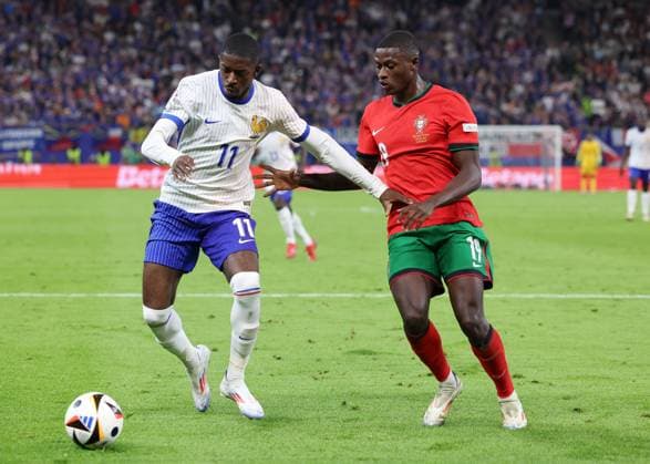 Hamburg, Germany, 5th July 2024. Ousmane Dembele of France tussles with Nuno Mendes of Portugal during the UEFA European Championships Quarter Final match at Volksparkstadion, Hamburg. Picture credit should read: Paul Terry Sportimage EDITORIAL USE ONLY. No use with unauthorised audio, video, data, fixture lists, club league logos or live services. Online in-match use limited to 120 images, no video emulation. No use in betting, games or single club league player publications. SPI-3217-0047