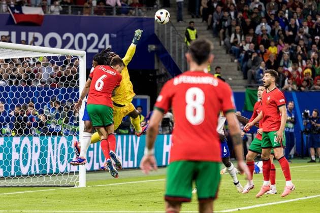 5th July 2024; Volksparkstadion, Hamburg, Germany; Euro 2024 Quarter Final Football, Portugal versus France; Jules Kounde (FRA) and Joao Palhinha (POR) as keeper Mike Maignan (FRA) punches clear of his goal  ActionPlus12664494 FotoxOlimpik