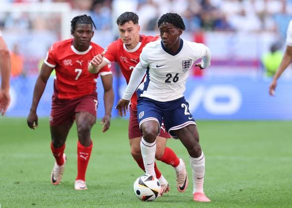 Dusseldorf, Germany, 6th July 2024. Kobbie Mainoo of England with the ball ahead of Zeki Amdouni of Switzerland during the UEFA European Championships Quarter Final match at Dusseldorf Arena, Dusseldorf. Picture credit should read: Paul Terry Sportimage EDITORIAL USE ONLY. No use with unauthorised audio, video, data, fixture lists, club league logos or live services. Online in-match use limited to 120 images, no video emulation. No use in betting, games or single club league player publications. SPI-3218-0153