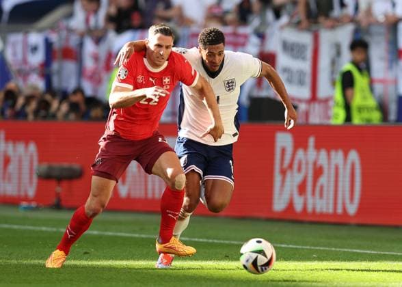 Dusseldorf, Germany, 6th July 2024. Fabian Schar of Switzerland and Jude Bellingham of England challenge for the ball during the UEFA European Championships Quarter Final match at Dusseldorf Arena, Dusseldorf. Picture credit should read: Paul Terry Sportimage EDITORIAL USE ONLY. No use with unauthorised audio, video, data, fixture lists, club league logos or live services. Online in-match use limited to 120 images, no video emulation. No use in betting, games or single club league player publications. SPI-3218-0168