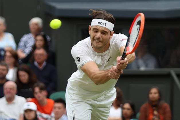 USA s Taylor Fritz plays a backhand in his fourth round match against Germany s Alexander Zverev at the 2024 Wimbledon Championships in London on Monday, July 08, 2024.  LON2024070836 HUGOxPHILPOTT