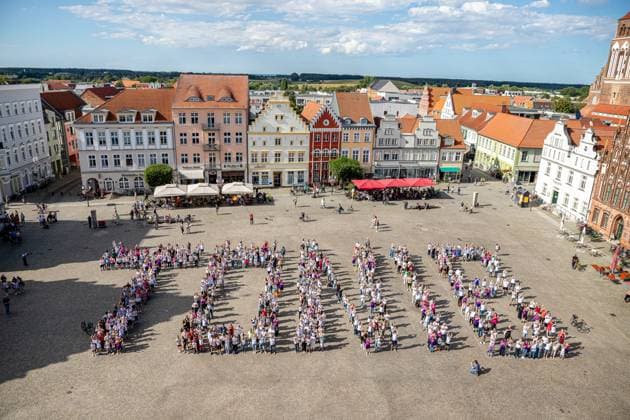 550 Menschen bilden eine Toni 8 zur Ehrung des Ausnahmespielers, der in der Hansestadt Greifswald geboren wurde. GER, Hansestadt Greifsald, Toni Kroos, Ehrung, HGW, Marktplatz, Fans, Fussball