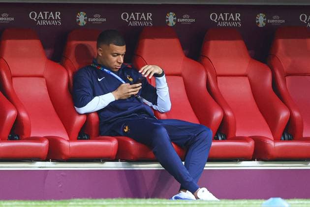 Kylian MbappÃ of France sits on their phone in the dugout during the arrivals Spain v France, UEFA European Championship, EM, Europameisterschaft 2024, Semi Final, Football, Munich Football Arena, Munich, Germany - 09 Jul 2024 EDITORIAL USE ONLY No use with unauthorised audio, video, data, fixture lists, club league logos or live services. Online in-match use limited to 120 images, no video emulation. No use in betting, games or single club league player publications.  Copyright: xKieranxMcManus Shutterstockx 14576874n