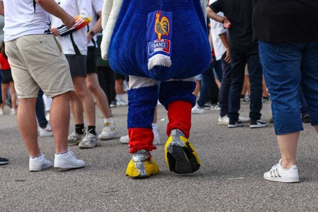 Spain v France 9 July 2024, Munich - UEFA EUROs - Semi-Final - Spain v France - A France fan dressed as a cockerel with a scarf for a tail walks through a crowd of spectators dressed normally - Photo: Charlotte Wilson Offside. Munich Germany Copyright: xCharlottexWilsonx xOffsidexOffside