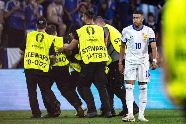 240709 Stewards take care of a pitch invader next to Kylian MbappÃ of France during the UEFA EURO, EM, Europameisterschaft,Fussball 2024 Football Championship semifinal between Spain and France on July 9, 2024 in Munich. Photo: Mathias Bergeld BILDBYRAN kod MB MB0944 fotboll football soccer fotball fotbolls-em europamästerskap em uefa euro uefa european football championship euro 2024 semifinal semifinals spanien spain frankrike france bbeng Copyright: MATHIASxBERGELD BB240709MB125