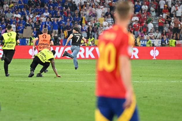 Bild zeigt: ein Flitzer wird von der Security gejagt, Dani Olmo (10, Spanien) schaut zu, 10.07.2024, München, Fussball, Europameisterschaft, Spanien - Frankreich, EVENT REGULATIONS PROHIBIT ANY USE OF PHOTOGRAPHS AS IMAGE SEQUENCES AND OR QUASI-VIDEO.