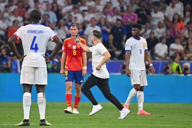 Flitzer mit Smartphone rennt ueber den Platz und macht Selfie. hi:Fabian RUIZ (ESP), re: Aurelien TCHOUAMENI (FRA). Halbfinale Spanien (ESP) - Frankreich (FRA) 2-1 am 09.07.2024, Fussball Arena Muenchen. Fussball UEFA EURO, EM, Europameisterschaft,Fussball 2024 GERMANY vom 14.06.2024 - 14.07.2024.