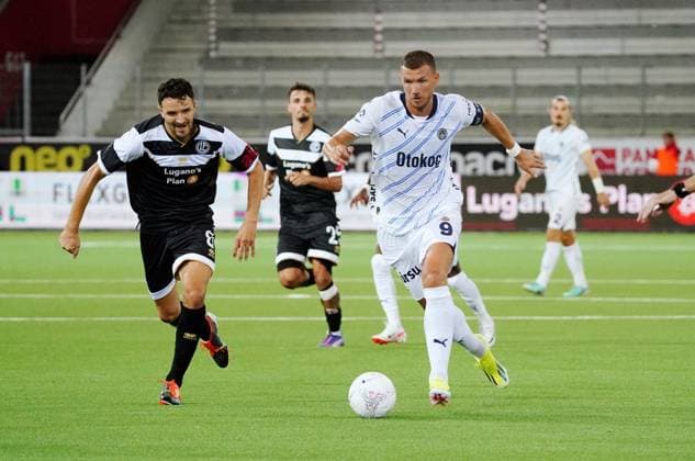 Anton Geisser 23.07.2024 Thun Schweiz. Fussball Herren 2024 2025 Qualifikation UEFA Champions League FC Lugano - Fenerbahce SK Istanbul. Bild : Anto Grgic (FC Lugano) gegen Edin Dzeko (Fenerbahce SK ) (r.) Zweikampf Aktion