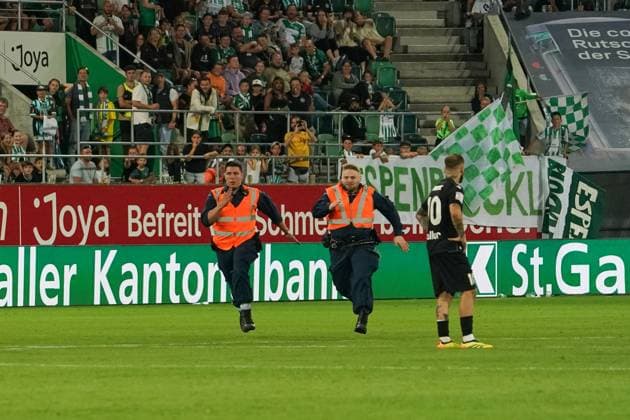 Fußball: FC St. Gallen 1879 vs. FC TOBOL KOSTANAY - 2. Qualifikationsrunde UEFA Conference League - Kybunpark St. Gallen, Schweiz: Zwei Sicherheitsmitarbeiter rennen auf dem Platz um einen Flitzer zu fangen. St. Gallen Kybunpark Kanton St. Gallen Schweiz Copyright: xJoeranxSteinsiekx