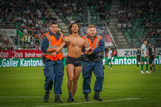 Fußball: FC St. Gallen 1879 vs. FC TOBOL KOSTANAY - 2. Qualifikationsrunde UEFA Conference League - Kybunpark St. Gallen, Schweiz: Ein halbnackte Flitzer macht ein Selfie Foto mit St. Gallens Torhüter Lawrence Ati Zigi und wird von Sicherheitskräften vom Spielfeld geführt. St. Gallen Kybunpark Kanton St. Gallen Schweiz Copyright: xJoeranxSteinsiekx